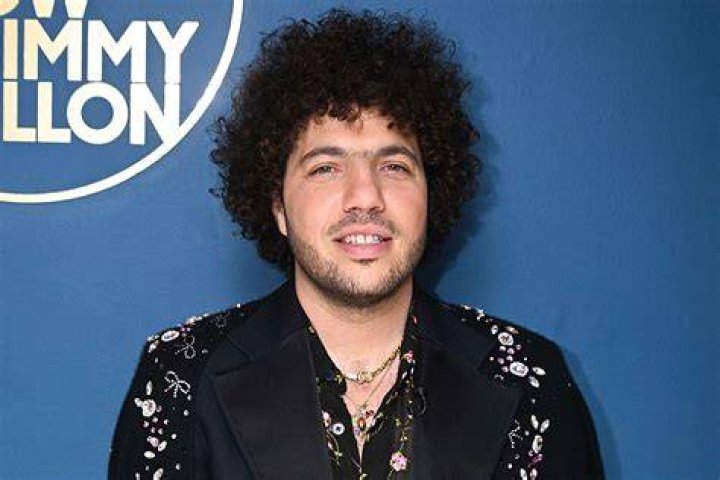 Benny Blanco poses while wearing an all-white suite